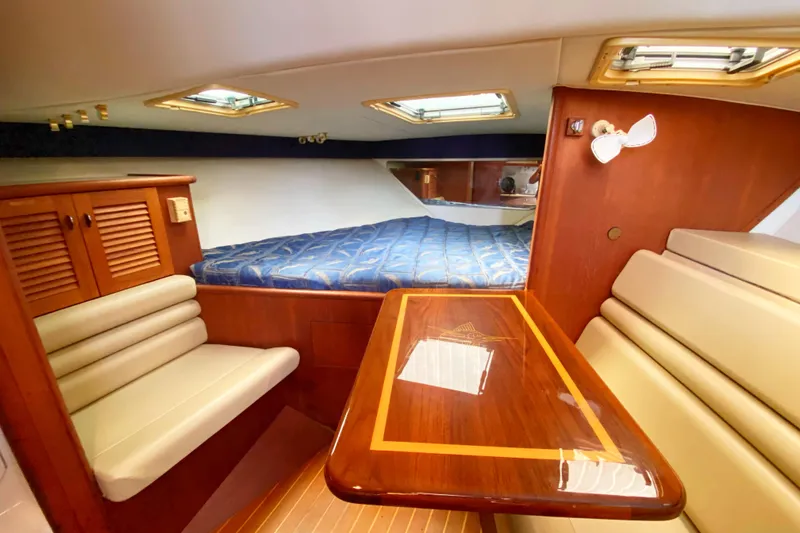 Slide: The Image of Interior of 2001 Pursuit 3000 Offshore boat with cozy seating and bed. - 33