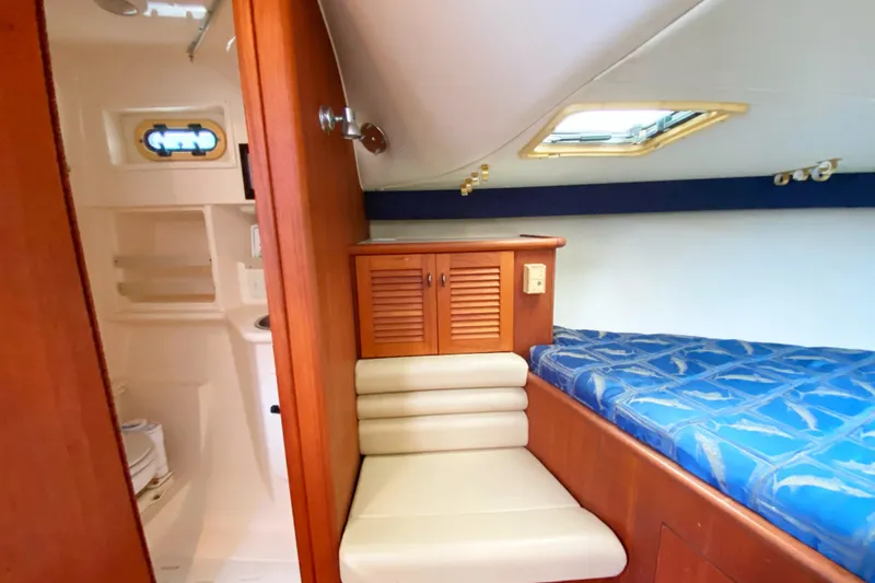 Slide: The Image of 2001 Pursuit 3000 Offshore cabin interior with bed, seating, and storage. - 35