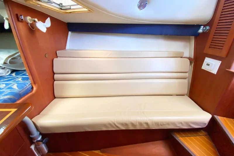 Slide: The Image of 2001 Pursuit 3000 Offshore cabin interior with beige seating and wooden accents. - 39