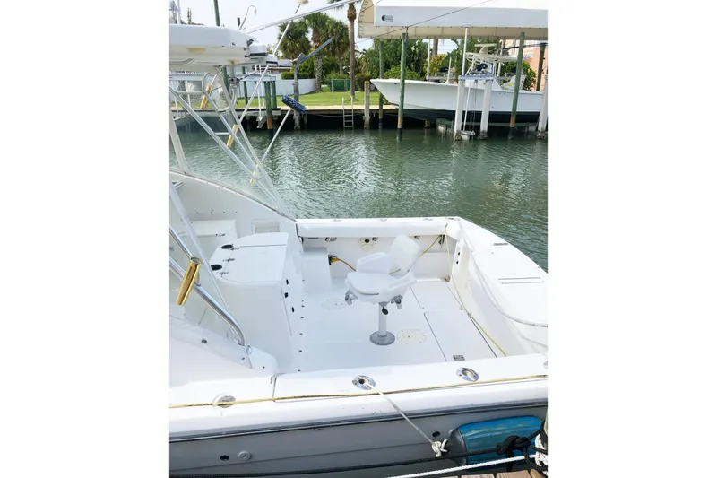 Slide: The Image of 2001 Pursuit 3000 Offshore boat docked, featuring spacious deck and seating area. - 4