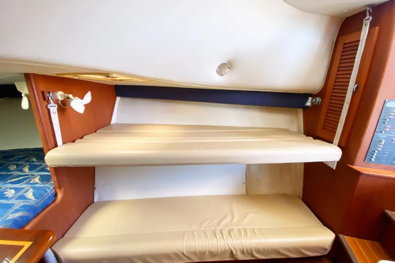 Slide: The Image of 2001 Pursuit 3000 Offshore cabin interior with beige seating and wooden accents. - 40