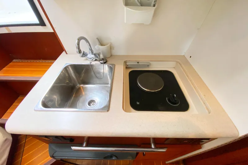 Slide: The Image of Compact kitchen area in a 2001 Pursuit 3000 Offshore boat with sink and stove. - 44