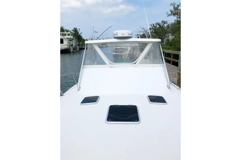 Slide: The Image of 2001 Pursuit 3000 Offshore boat docked, featuring a sleek white deck and windshield. - 5