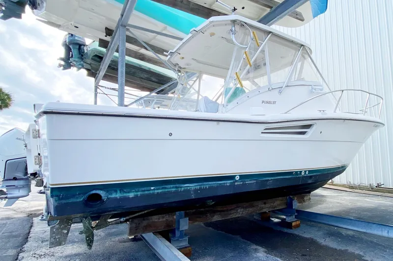 Slide: The Image of 2001 Pursuit 3000 Offshore boat on dry dock, side view. - 6