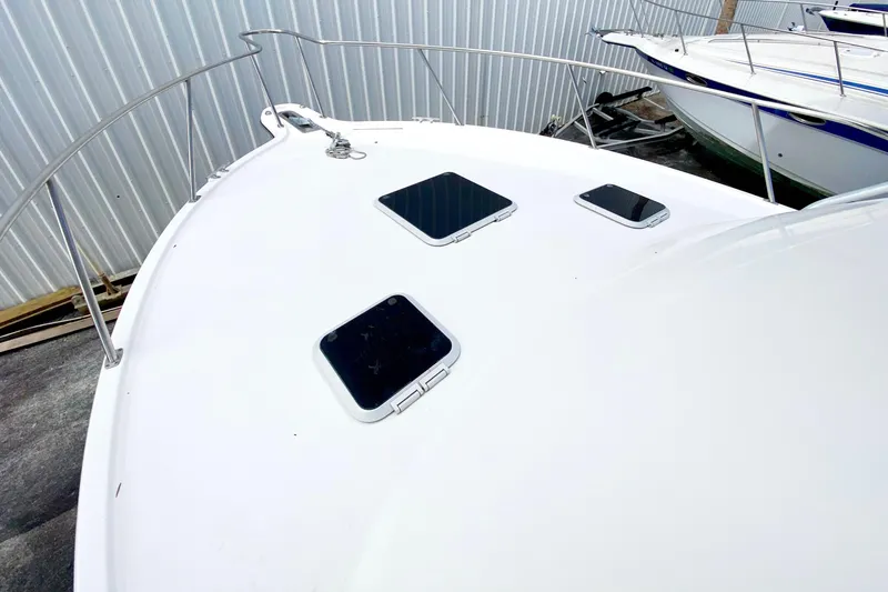 Slide: The Image of 2001 Pursuit 3000 Offshore boat deck with hatches, docked near other vessels. - 7