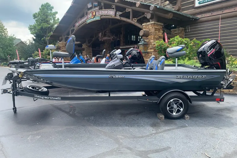 The Image of 2026 Ranger RT188P fishing boat on trailer outside a rustic store. - 0