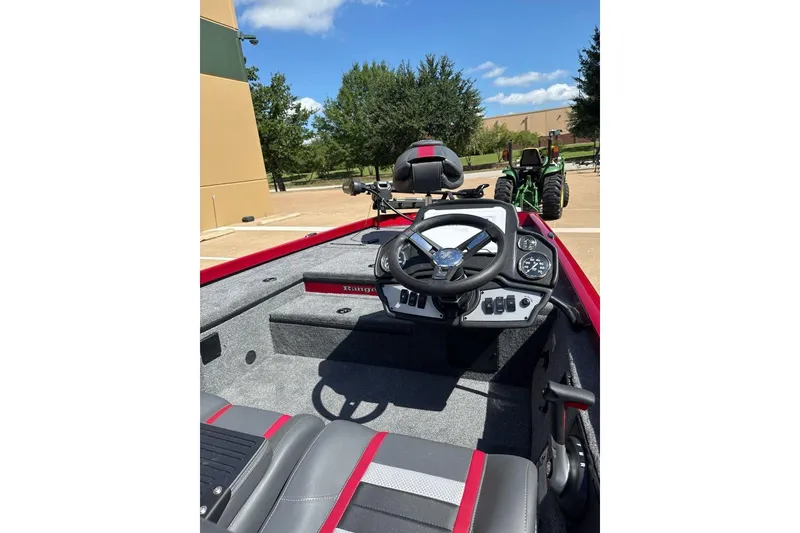 Slide: The Image of 2026 Ranger RT178 boat interior with steering wheel and dashboard, parked outdoors. - 8