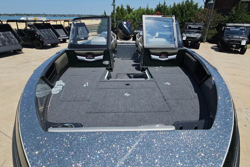 Slide: The Image of 2026 Ranger 1850MS boat with sparkling deck, parked outdoors near utility vehicles. - 10