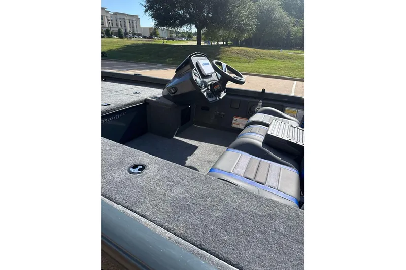 Slide: The Image of 2026 Ranger RT188C boat interior with steering wheel and seating, parked outdoors. - 4