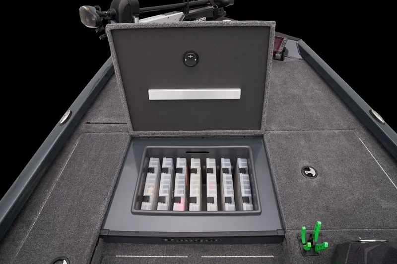 Slide: The Image of 2026 Ranger RT178 boat storage compartment with organized tackle boxes on a carpeted deck. - 24