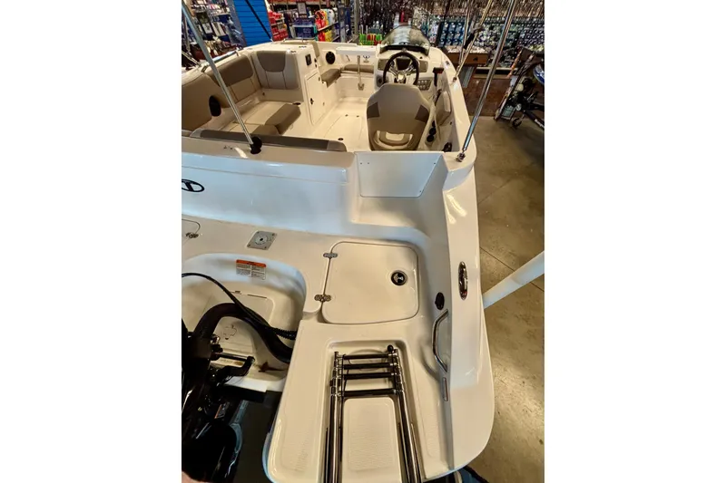 Slide: The Image of 2026 Tahoe 2150 boat interior with seating and steering wheel, displayed in a showroom. - 96