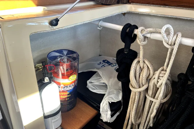 Slide: The Image of Storage area in a 2013 Ranger Tugs R-27 with ropes, fire extinguisher, and safety equipment. - 18