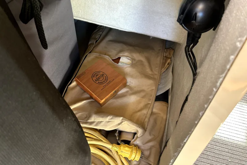 Slide: The Image of Storage compartment in 2013 Ranger Tugs R-27 with wooden box and coiled yellow cable. - 19