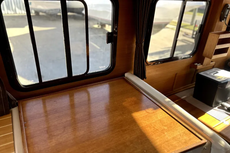 Slide: The Image of Interior of 2013 Ranger Tugs R-27 with wooden table and large windows. - 21