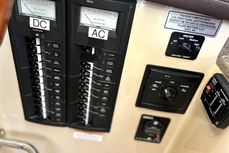 Slide: The Image of Electrical control panel on a 2013 Ranger Tugs R-27 boat, featuring DC and AC switches. - 22
