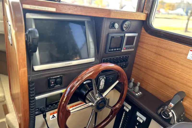 Slide: The Image of 2013 Ranger Tugs R-27 helm with Garmin navigation and wooden steering wheel. - 30