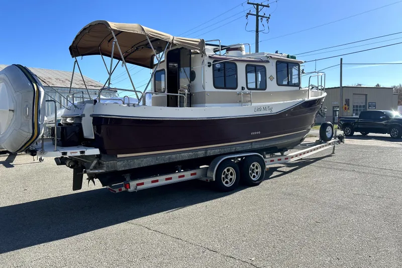 Slide: The Image of 2013 Ranger Tugs R-27 boat on trailer, parked outdoors under clear sky. - 4