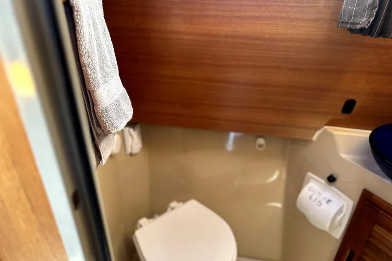 Slide: The Image of 2013 Ranger Tugs R-27 boat bathroom with wooden accents and towel. - 41