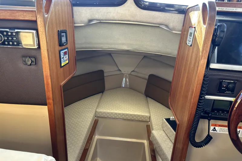 Slide: The Image of Interior cabin of 2013 Ranger Tugs R-27 boat with wood paneling and navigation equipment. - 45