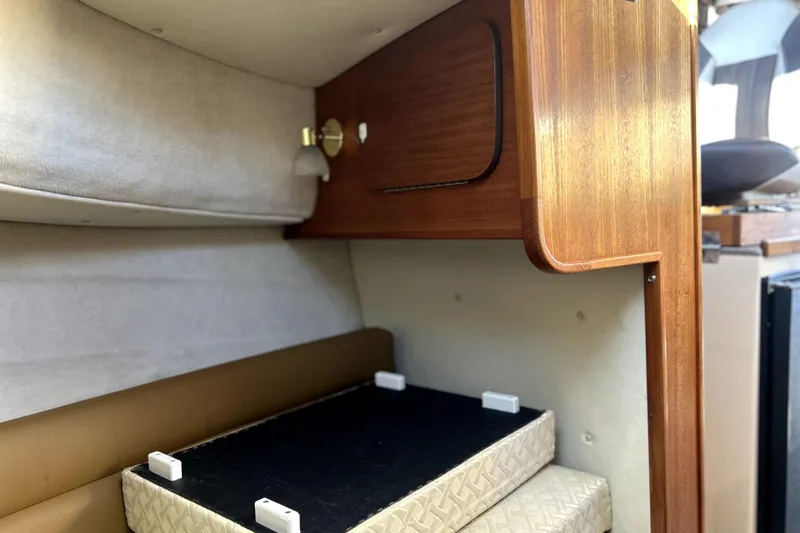 Slide: The Image of 2013 Ranger Tugs R-27 cabin interior with wooden cabinetry and cushioned seating. - 49