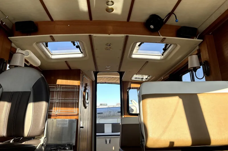 Slide: The Image of Interior of 2013 Ranger Tugs R-27 boat with seating and ceiling windows. - 50