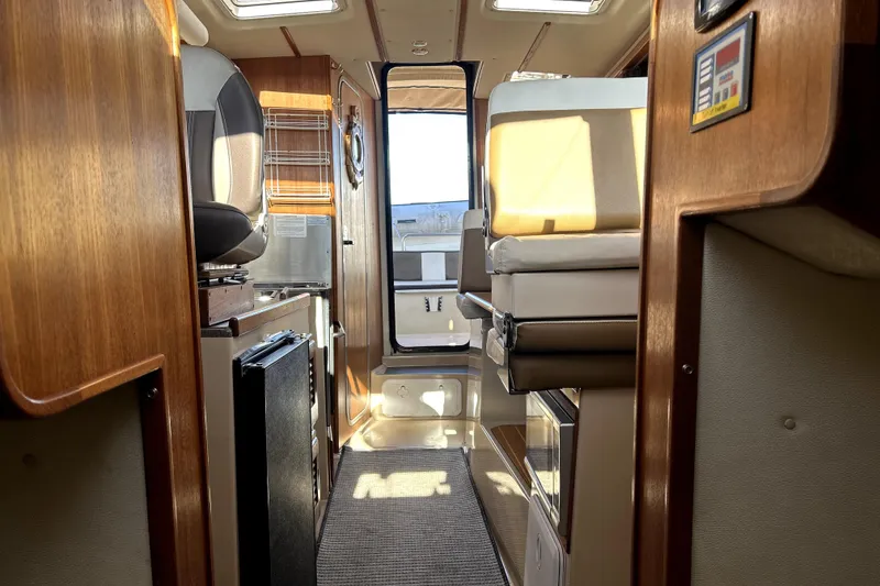 Slide: The Image of Interior of 2013 Ranger Tugs R-27 boat, featuring wood finishes and compact design. - 51