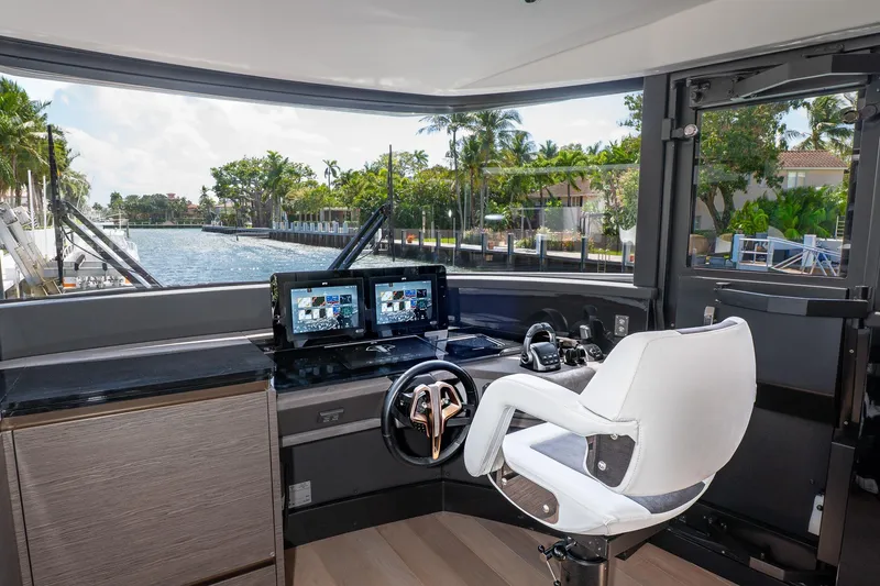 Slide: The Image of 2024 Explorer EX62 yacht helm with dual screens and luxurious white captain's chair. - 15
