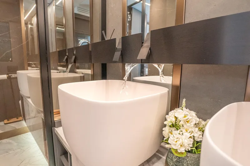 Slide: The Image of Modern bathroom with sleek white sink, elegant faucet, and decorative flowers. - 33