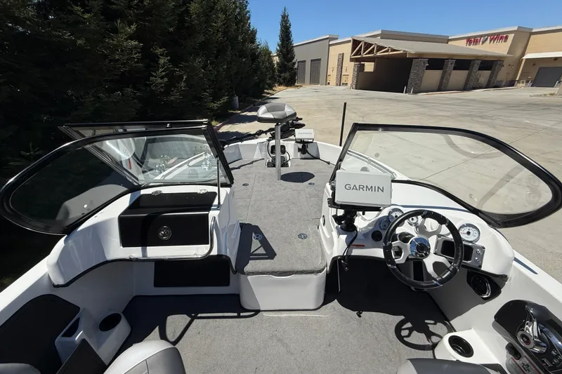 Slide: The Image of 2026 Nitro ZV19 Sport Pro boat interior with Garmin navigation system, parked near a building. - 9