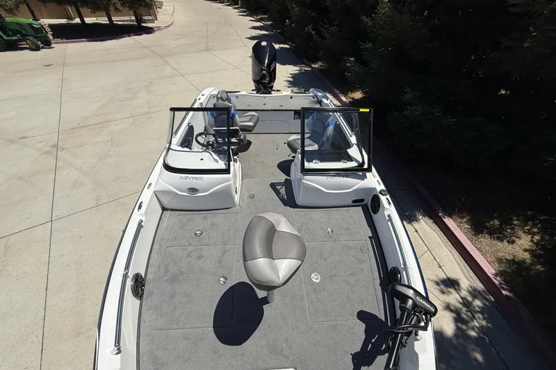 Slide: The Image of 2026 Nitro ZV19 Sport Pro boat with open deck and seating, parked on concrete. - 13