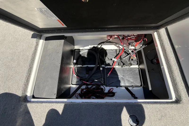 Slide: The Image of Open battery compartment of 2026 Nitro ZV19 Sport Pro boat, showing wiring and components. - 31