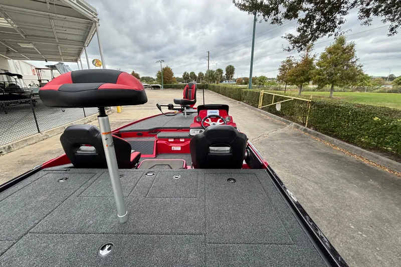 Slide: The Image of 2026 Nitro Z20 XL boat interior with red and black seating, parked outdoors. - 24