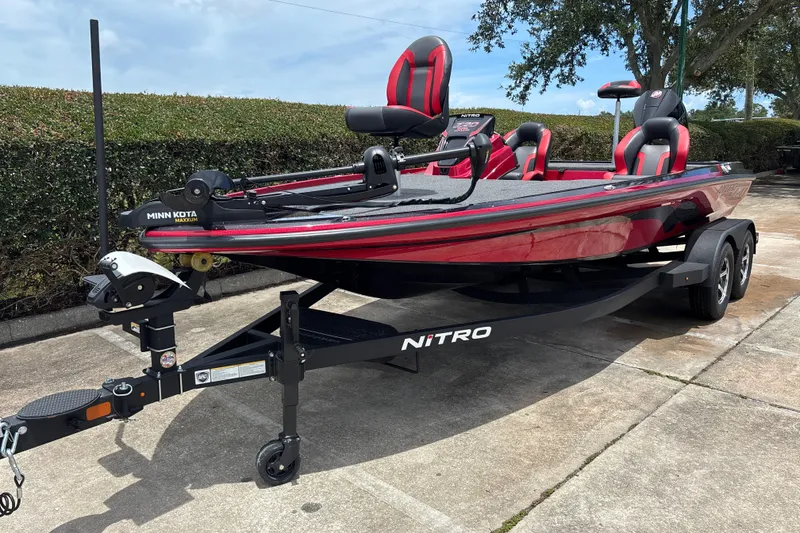 Slide: The Image of 2026 Nitro Z20 XL boat with Minn Kota trolling motor on trailer, parked outdoors. - 1