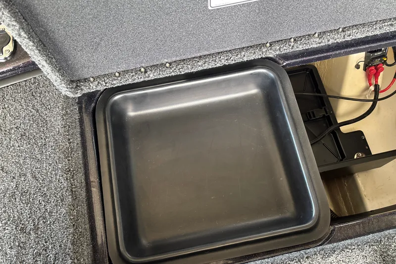 Slide: The Image of Storage compartment in 2026 Nitro Z20 XL boat, featuring a black tray and battery connections. - 30