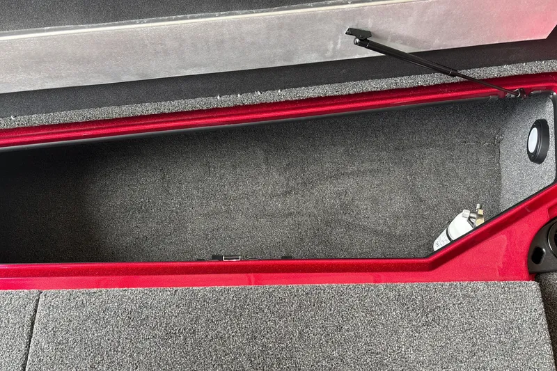 Slide: The Image of Open storage compartment in 2026 Nitro Z20 XL boat, featuring carpeted interior and red trim. - 24