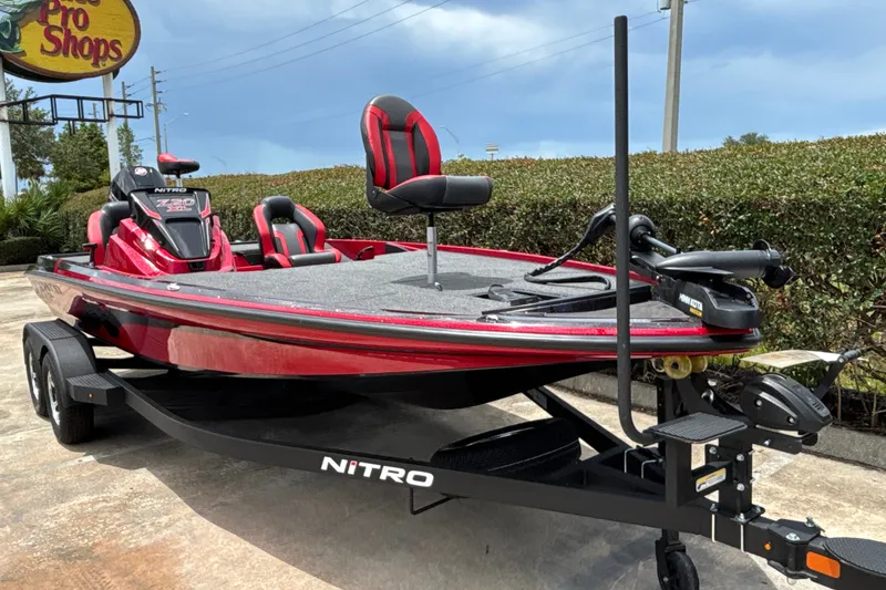 Slide: The Image of Red 2026 Nitro Z20 XL boat on trailer, parked outdoors near Bass Pro Shops. - 5