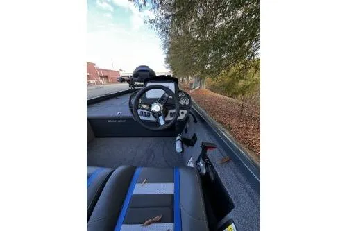 Slide: The Image of 2026 Ranger RT178C boat interior with steering wheel and dashboard, parked outdoors. - 5