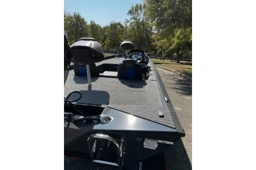 Slide: The Image of 2026 Ranger RT188C boat on a sunny day, parked on a tree-lined road. - 2