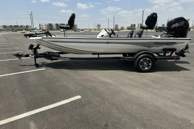 The Image of 2026 Ranger RT188 boat in parking lot, side view, on trailer under clear sky. - 0