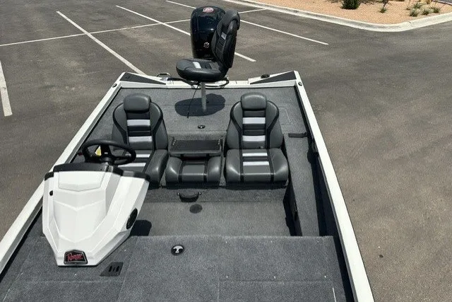 Slide: The Image of 2026 Ranger RT188 boat interior with seating and steering console in a parking lot. - 18