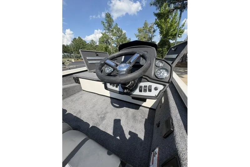 Slide: The Image of 2026 Ranger RT188 boat dashboard with steering wheel and gauges under clear blue sky. - 1