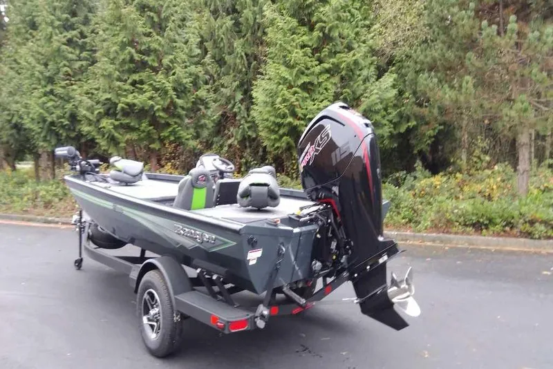 Slide: The Image of 2026 Ranger RT188 boat with motor on trailer, parked near lush greenery. - 101