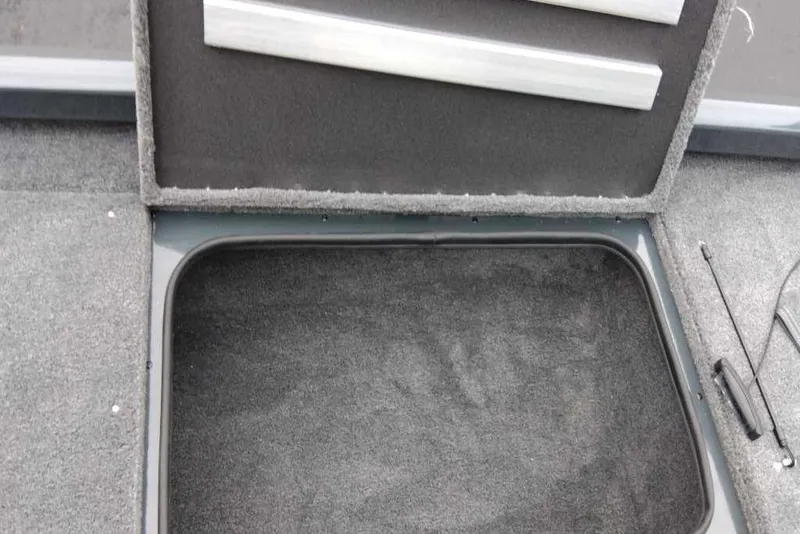 Slide: The Image of Open storage compartment in 2026 Ranger RT188 boat, featuring carpeted interior. - 104