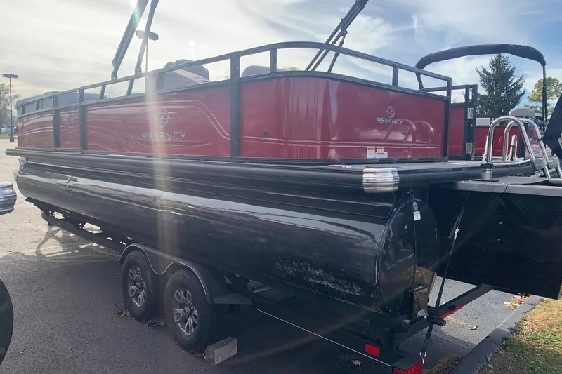 Slide: The Image of 2024 Regency 250 DL3 pontoon boat on trailer, red and black design. - 5