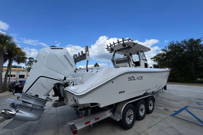 Slide: The Image of 2026 Solace 32 CS boat on trailer, featuring Mercury outboard engine, under blue sky. - 11