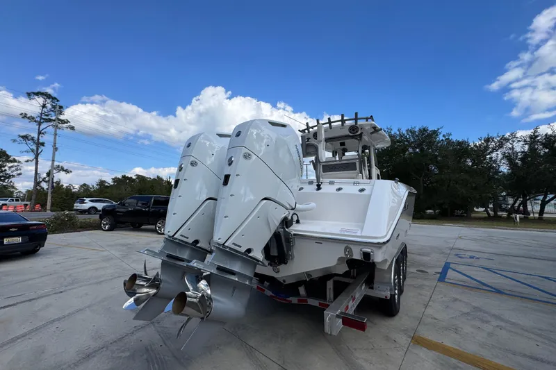 Slide: The Image of 2026 Solace 32 CS boat with dual outboard engines in a parking lot. - 12