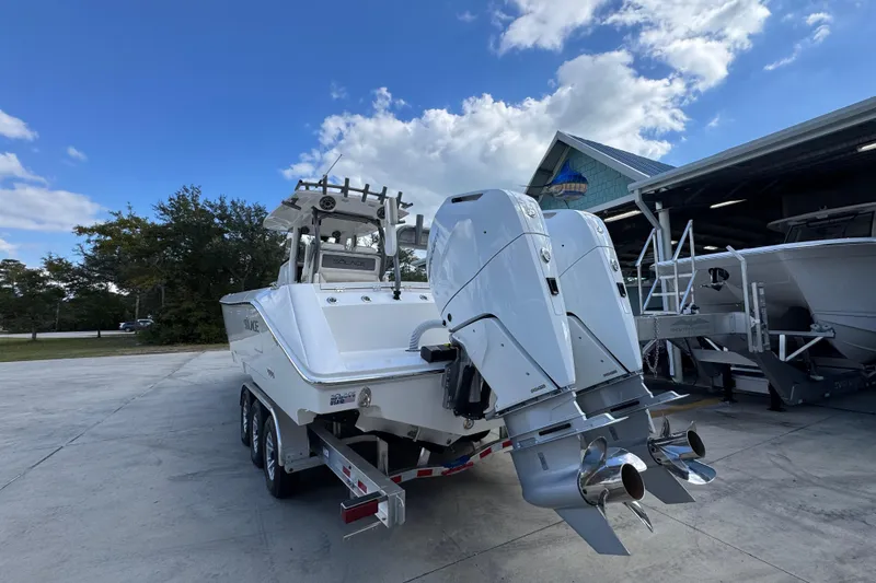 Slide: The Image of 2026 Solace 32 CS boat with dual engines on a trailer, parked outdoors. - 14