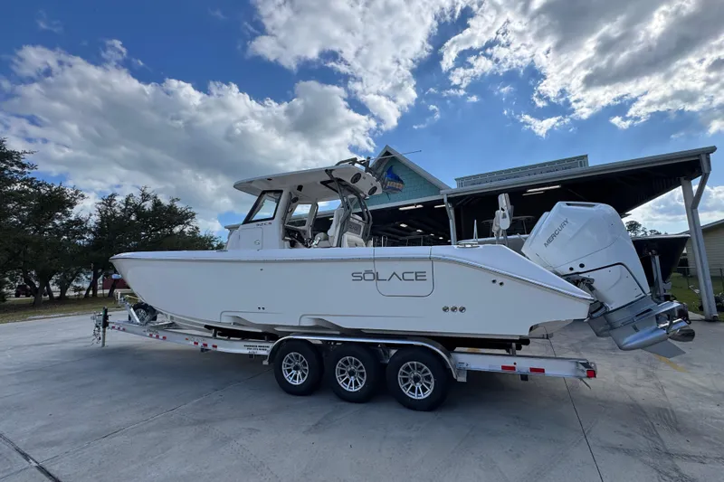 Slide: The Image of 2026 Solace 32 CS boat on trailer under cloudy sky. - 16