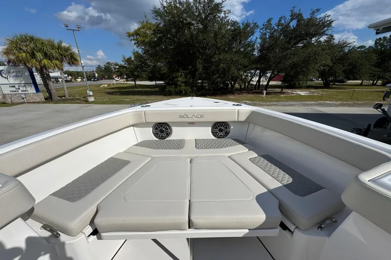 Slide: The Image of 2026 Solace 32 CS boat interior with cushioned seating and speakers, under a clear blue sky. - 18