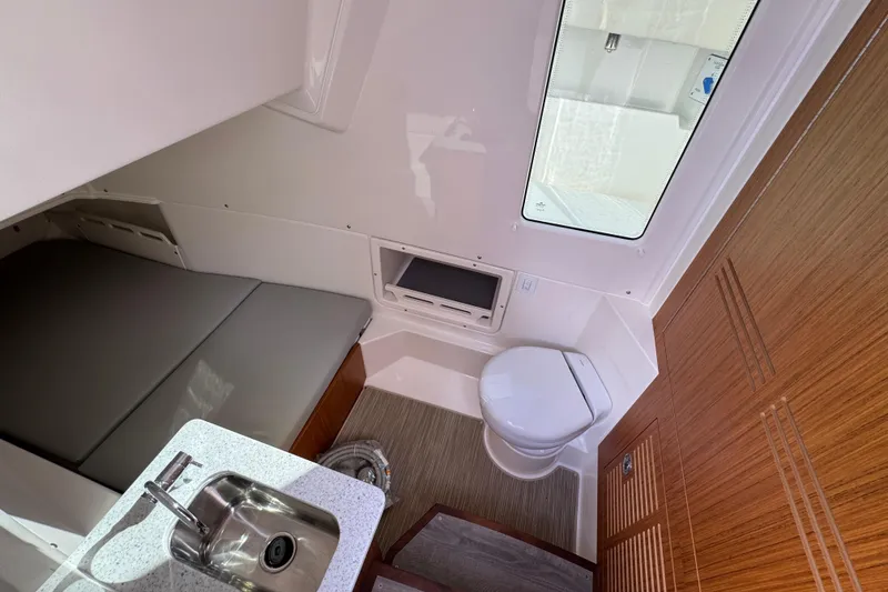 Slide: The Image of Interior of 2026 Solace 32 CS boat featuring a compact bathroom and sleeping area. - 28